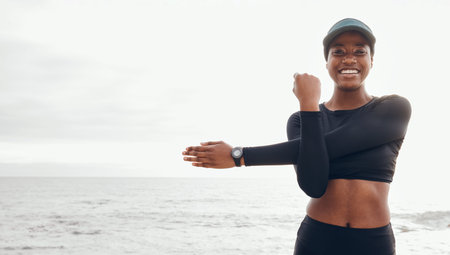Portrait of woman stretching by ocean for fitness in nature for exercise, marathon training and...