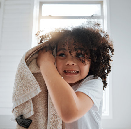 Bathroom, towel or child washing hair in shower in daily morning grooming routine at home. Biracial kid, natural or young boy cleaning for wellness, hydration or healthy haircare with afro hairstyleの写真素材