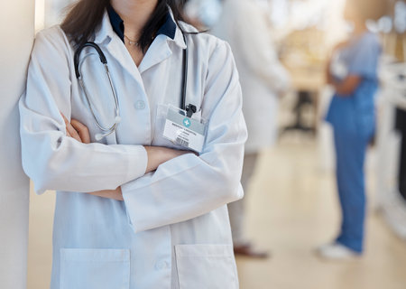Hospital, doctor and crossed arms of woman with stethoscope for cardiology, consulting and medical service. Healthcare, clinic and female health worker with equipment for support, exam and wellnessの写真素材