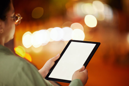 Woman, hands and tablet with mockup at night in city for communication, networking or browsing outdoors. Hand of female person or freelancer working late with technology display in an urban townの写真素材