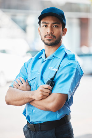 Security guard, safety officer and portrait of a man on street for protection, patrol or watch. Law enforcement, serious and walkie talkie of a crime prevention male worker in uniform outdoor in cityの写真素材