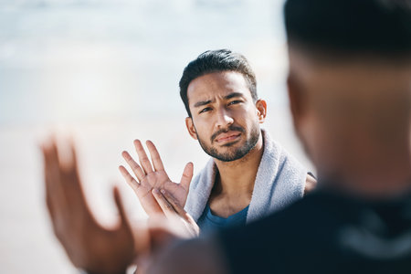 Sign language, communication and friends talking on the beach during summer vacation or holiday together. Face, conversation and travel with a young man chatting outdoor in nature by the oceanの写真素材
