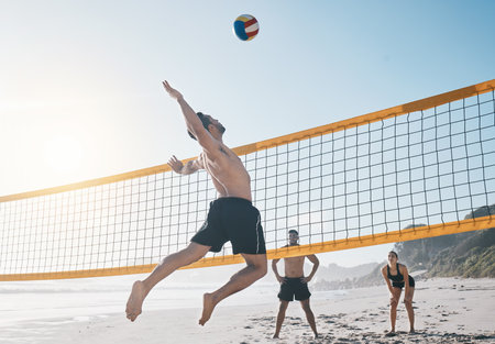 Man, jump and volleyball in air on beach by net in sports match, game or competition. Body of male person jumping for ball in volley or spike in healthy fitness, energy or exercise by the ocean coastの写真素材