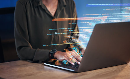 Laptop, coding hologram and business woman for software development, programming and cybersecurity in night office. Typing, research and programmer or IT person hands on computer in data html overlayの写真素材