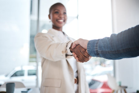 Black woman, handshake and meeting in partnership, support or trust for teamwork or unity at office. African female person or employee shaking hands for introduction, agreement or deal at workplaceの写真素材