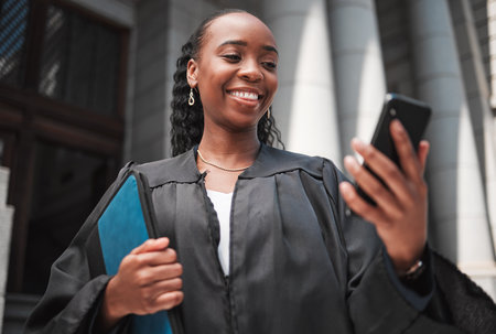 Judge, court or lawyer with phone to contact a client, communication or legal services and advice on mobile app online. Smile, black woman and smartphone for research, information or consulting lawの写真素材