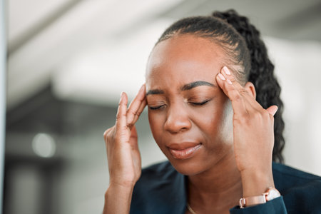 Stress, head pain or black woman in office with headache due to burnout or fatigue from deadline. Migraine, crisis or tired African female consultant depressed or frustrated by anxiety in workplaceの写真素材