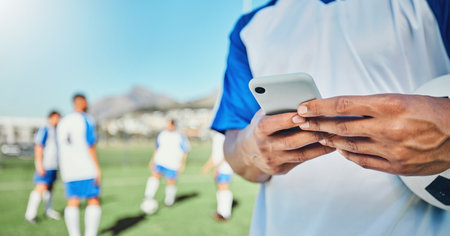 Football, field, phone and man hands for competition, training or fitness news, social media chat and blog. Soccer player or person typing on mobile app for sports information, health or goal checkの写真素材