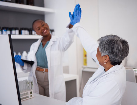 Women, scientist and high five with success in laboratory, teamwork and scientific breakthrough in medical research. Collaboration, science and biotechnology, female doctors has support and celebrateの写真素材