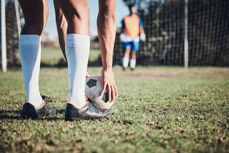 Soccer ball, sports and feet of person to kick on field, fitness training or shoot for a goal in the...