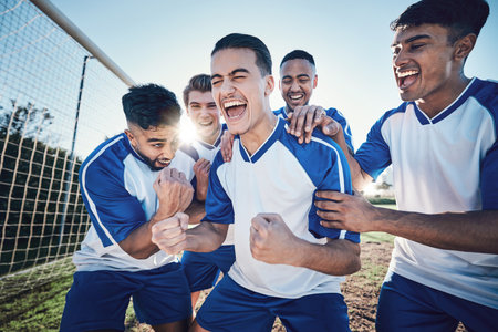 Winning, goal and soccer player with team and happiness, men play game with sports and celebration on field. Energy, action and competition with male athlete group, cheers and diversity with successの写真素材