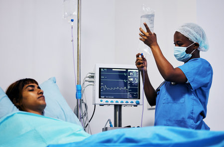 Hospital, nurse with face mask and iv drip for patient in bed, clinic or medical emergency, surgery and person with life insurance. Nursing, doctor or surgeon with medicine or healthcare workerの写真素材