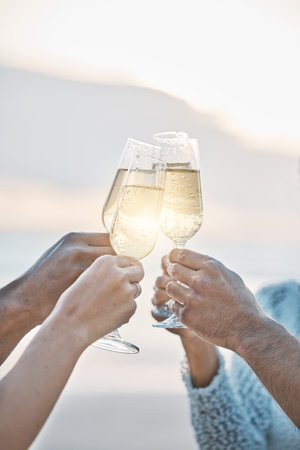 Sunset, friends and hands toast with champagne, having fun or bonding together. Vacation, group and people cheers with wine glass, alcohol or drink for celebration on holiday, summer or party outdoorの写真素材