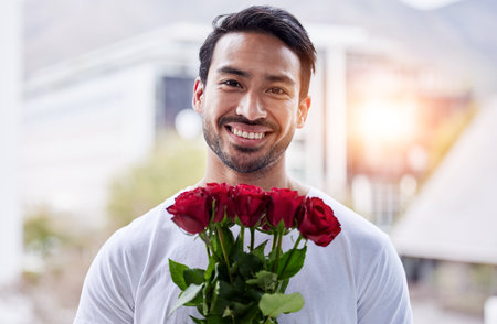 Smile, portrait and man with bouquet of roses for date, romance and hope for valentines day. Love confession, romantic gift and happy male holding flowers outside in city for proposal or engagement.の写真素材