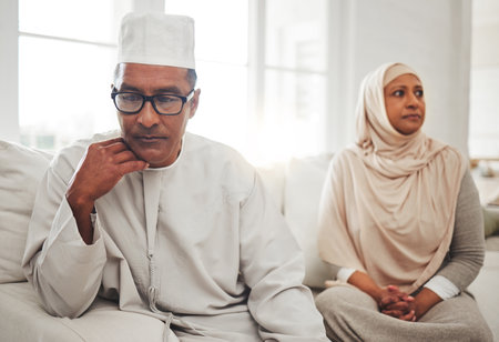 Muslim couple, fight or mature man with depression, problem or divorce conflict in home living room. Sad, crisis or marriage fail for thinking Islamic people in house stress, mental health or anxietyの写真素材