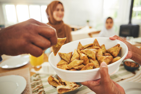 Food, samosa and muslim with hands of people at table for eid mubarak, Islamic celebration and...