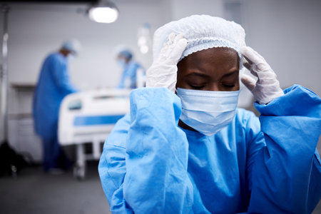 Black woman, stress or sad surgeon in surgery grieving after loss, operation failure or bad news in hospital. Depression, mask or upset doctor thinking with anxiety thinking of operating room mistakeの写真素材