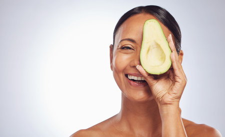 Skincare, face and mature woman with avocado in studio isolated on a white background mockup. Happy, natural fruit and portrait of senior model with nutrition, healthy diet and omega 3 for anti agingの写真素材