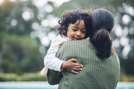 Love, trust and child hug mother at outdoor park bonding for care and happy for quality time together in nature. Smile, mama and kid embrace parent or mom for happiness and support in mockup spaceの写真素材