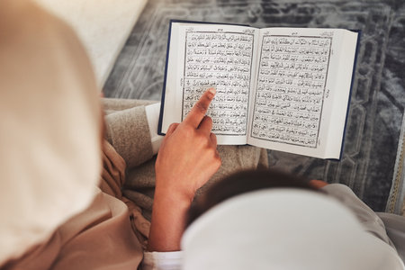 Prayer, muslim and Quran with child and learning for eid mubarak, God and worship. Islamic, hope and Ramadan with hands of family teaching arabic on mat at home for faith, religion and gratitudeの写真素材