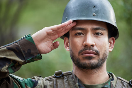 Army, man and salute portrait in military of a veteran with security, protection and battle. Male person, soldier and serious face with surveillance, hero and war leader with camouflage in natureの写真素材