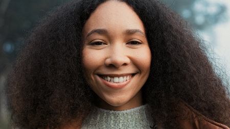Portrait, face and a happy woman outdoor in nature to relax and breathe fresh air. Vacation, calm woods and closeup of a young african girl on holiday or hike on misty morning with a confident smileの写真素材