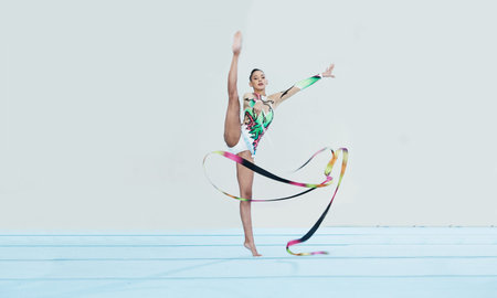 Gymnastics training, woman and ribbon with legs split for competition, sport and balance in portrait. Gymnast, athlete girl or professional dancer for concert, performance and contest with creativityの写真素材