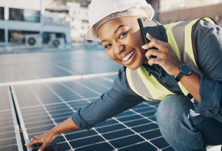 Portrait of happy black woman, solar panel and phone call for photovoltaic plate, sustainability advice or maintenance. Eco friendly energy, cellphone and female engineer smile for power saving checkの写真素材