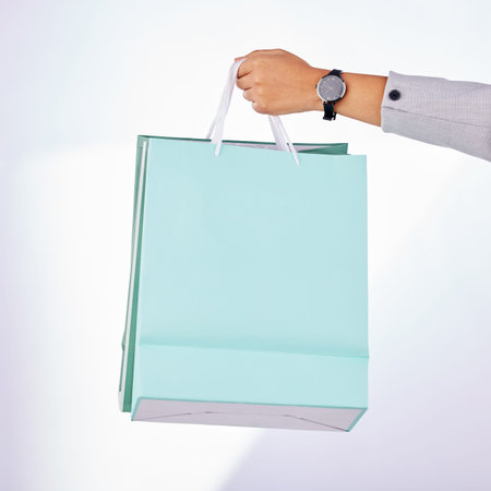 Hands, person and bag of shopping in studio, white background or fashion deal in retail product....