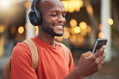 City, headphones and black man with smartphone, typing and connection with social media, audio and...