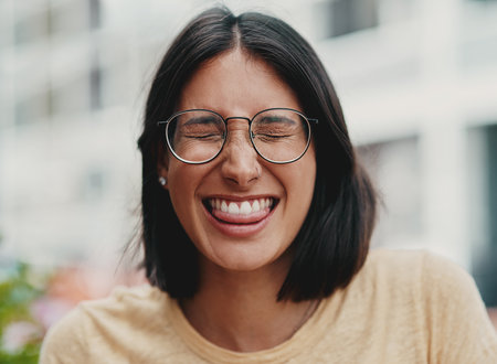 A little bit of fun never hurt anyone. Cropped shot of an attractive young businesswoman sitting alone outside and feeling playful while making a face.の写真素材