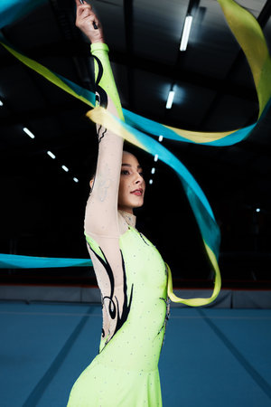 Ribbon, dance and rhythmic gymnastics, woman in gym with action and performance for fitness. Competition, athlete and female gymnast, dancer with creativity and art, routine and energy at arenaの写真素材