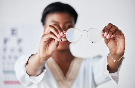 Hands, woman and optician with glasses for vision, eyesight and eye care prescription lens. Closeup of doctor, optometrist and frame for eyewear, test and consulting for optical assessment in clinicの写真素材