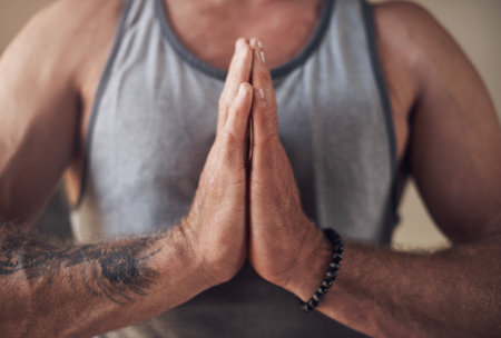 Taking the time to be grateful. Cropped shot of an unrecognizable man sitting with his palms together while meditating indoors.の写真素材