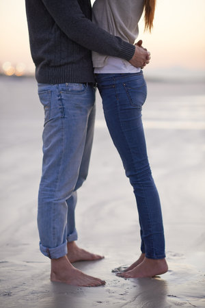 Love at the beach. A young couple enjoying each others company at the beach.の写真素材