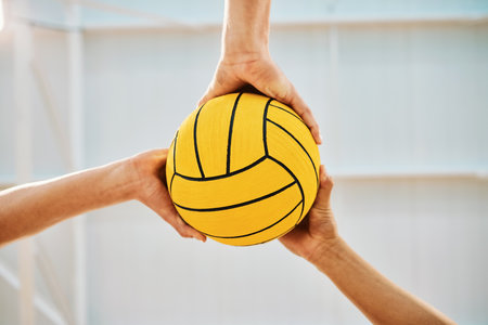 Hands, teamwork and water polo with sports people holding a ball in a gym for fitness or training from below. Exercise, game and solidarity with a group of athletes in a health center for a workoutの写真素材
