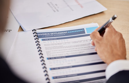 Divorce contract, hand and person sign legal paperwork, documents or settlement agreement for assets. Closeup pen, writing and businessperson compliance to marriage conclusion, policy or family lawの写真素材