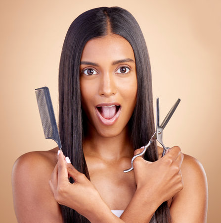 Comb, hair care or portrait of woman with surprise, scissors for self care beauty grooming on studio background. Shocked, wow or Indian girl in salon with tools or cosmetics for haircut treatmentの写真素材