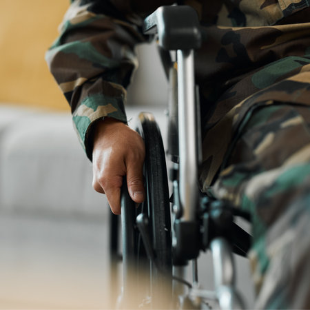 Man, hands and wheelchair in army from accident, war injury or healthcare support at hospital. Closeup of soldier or person with a disability holding wheel in commitment for recovery or physiotherapyの写真素材