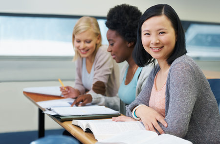 Her education is important to her. A group of students sitting in an exam room.の写真素材