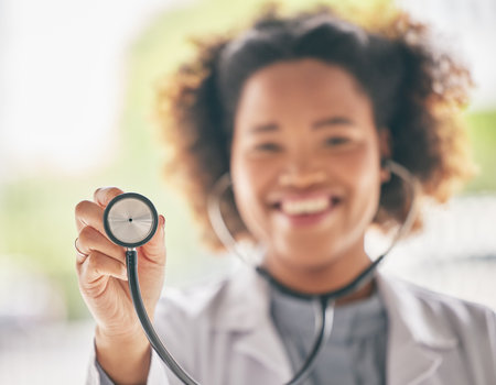 Healthcare, stethoscope and cardiology with a doctor in the hospital for a routine checkup during an appointment. Medical, hand and heart health with a woman medicine professional in a clinicの写真素材