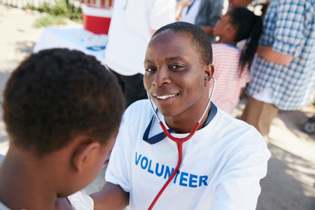 On a mission to provide great medical care. Shot of a volunteer doctor examining a young patient with a stethoscope at a charity event.の写真素材