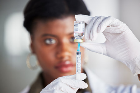 Vaccine vial, needle and doctor for safety, healthcare and pharmaceutical medicine. Closeup, hands of woman and prepare vaccination, virus injection and bottle for immunity, medical drugs or smallpoxの写真素材