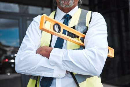 Man, arms crossed and architect has level, construction and confident in city, maintenance and...