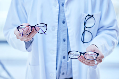 Glasses, choice and optometrist, hands and vision with eyewear in clinic, prescription lens with designer frame. Eyesight, eye care and optometry, healthcare and person with decision for spectaclesの写真素材