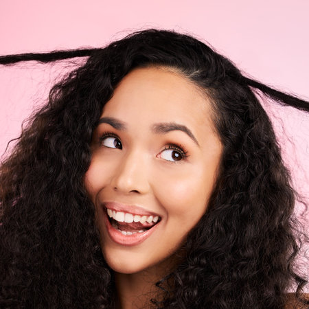 Beauty, curly hair and smile with face of woman in studio for cosmetics, textures and salon treatment. Shampoo, skincare and hairstyle with model on pink background for self care, facial and glowの写真素材
