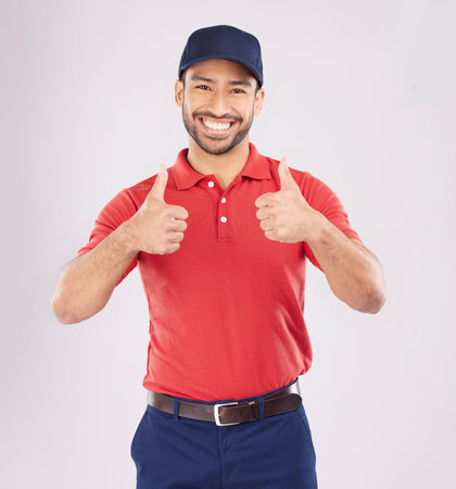 Thumbs up, smile and portrait of a happy man in studio with a hand sign for support or thank you. A young asian person on a white background for fashion clothes, like emoji and review or feedbackの写真素材