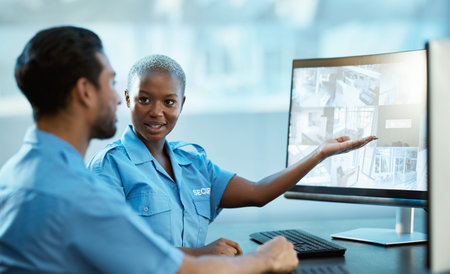 People, security and computer screen for surveillance, protection and safety of police officer in teamwork. Man and woman guard working together on PC for emergency footage or crime at the officeの写真素材