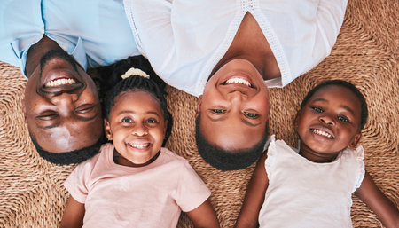 Above, parents or portrait of happy kids on floor in house or home bonding or playing as a black family. Faces, mother or African father relaxing with kids, girls or siblings with smile, care or loveの写真素材