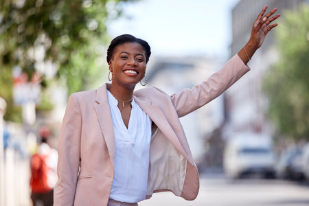 Happy black woman, taxi and travel in city waving or waiting for transportation on street sidewalk. African female person calling vehicle or signal with hand for ride service in road of an urban townの写真素材
